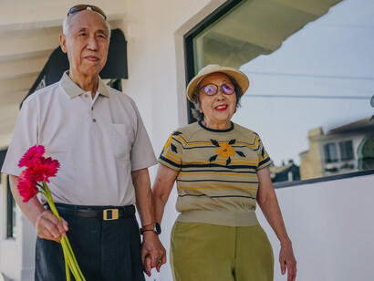 Casal de idosos andam de mãos dadas pelas ruas do bairro