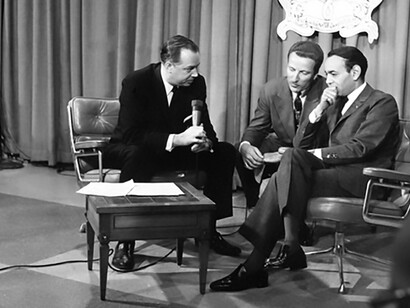 Florida Showcase in New York City, featuring the esteemed presence of King Hassan of Morocco (at right) as he engages with the Today Show. Witness the interview conducted by the show's star, Hugh Downs (at left), with the king's interpreter (center) facilitating communication
