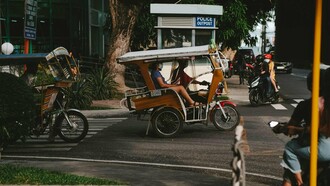 A person travelling in Dumaguete aboard a tricycle, representing the simple realities of provincial urban life
