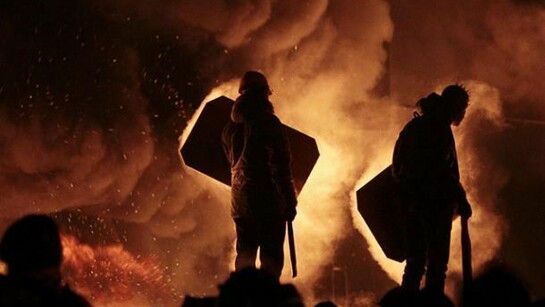 Figuras humanas ante el fuego y el humo causados por los incidentes y las protestas en Ucrania