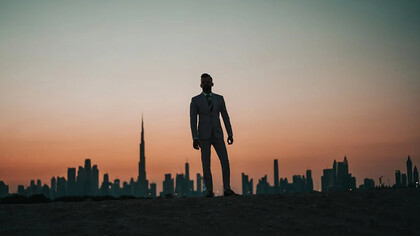 A man standing against the backdrop of Dubai’s iconic city skyline