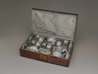 Vienna, Du Paquier, 1730. Servizio da tè e da caffè in 24 pezzi per 6 persone, con custodia originale, dipinto a motivi “Laub-und Bandelwerk” (foglie e intrecci) in “Schwarzlot” (monocromia nera) con rialzi in oro. 
