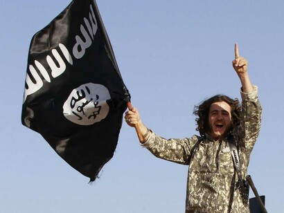 Miembro del Isis enarbola una bandera de la organización