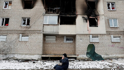 A woman weeps in front of her bombed home in Volnovakha, Ukraine, captured in a photograph by Alexander Ermochenko