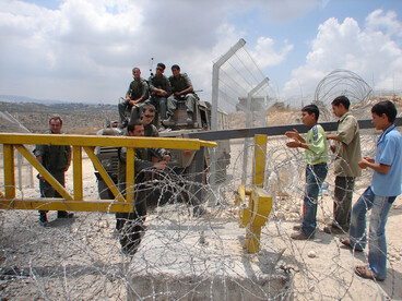 Manifestation d'enfants palestiniens à une porte de la barrière de séparation israélienne à Bil'in, en Cisjordanie occupée, juillet 2006. Cette porte est le seul moyen pour les villageois d'accéder à leurs terres agricoles. Photo par Harry Pockets