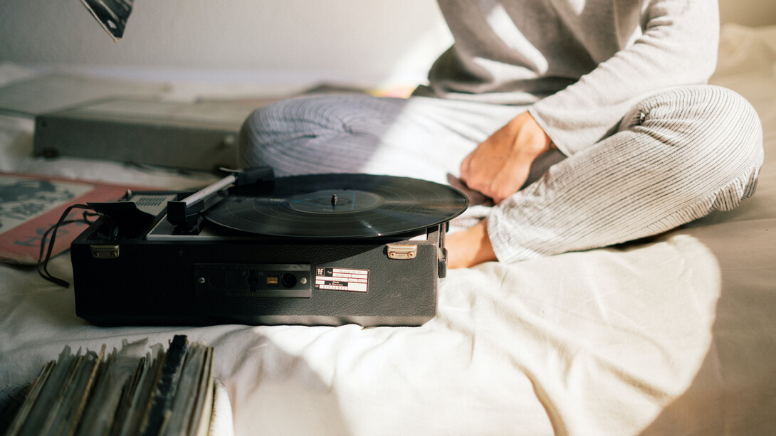Niño sentado en su cama con un tocadiscos