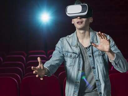 Jovem assiste a filme com tecnologia de realidade virtual. O cinema imersivo está ganhando espaço com o uso da realidade virtual (VR) e aumentada (AR). Essas tecnologias permitem que o espectador interaja com a narrativa, criando experiências personalizadas. O curta Carne y Arena (2017), de Alejandro Iñárritu, foi um marco nesse sentido, transportando o público para a perspectiva de imigrantes atravessando a fronteira dos EUA