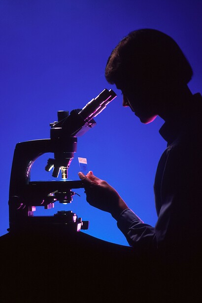 Scienziato studia vetrino al microscopio