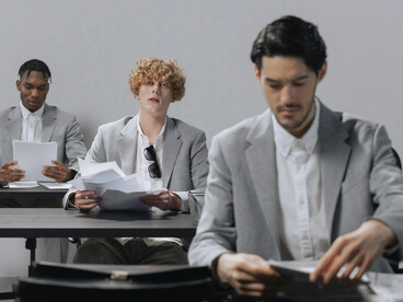 A group of men in an office, physically together yet conspicuously disconnected