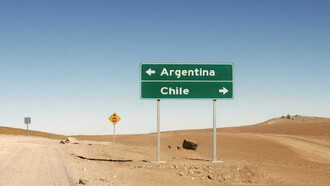 Border between Argentina and Chile in Bolivia, where the signs of both nations stand as symbols of national identity by L'odyssée Belle