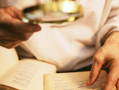 Pesquisador examina anotações pessoais para estudo biográfico. Os melhores biógrafos continuam a buscar mais do que simples curiosidades. Eles exploram as contradições, os silêncios e as ambiguidades de seus personagens. Não se trata apenas de exaltar ou condenar, mas de compreender