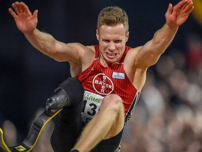 O atleta alemão Markus Rehm no meio de um salto