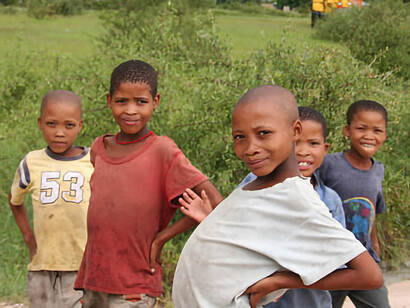 In a village near Tsumkwe, Namibia, San boys enjoy playing during the rainy season, despite facing the hardships of malnutrition and underdevelopment