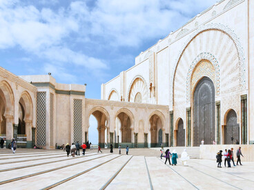 Visitors walking through the vast courtyard of the Hassan II Mosque, reflecting Morocco’s openness and shared public life