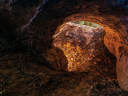 An ocre-tinted cave, an ideal spot for bears to sleep through the winter in