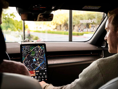 A man is sitting in a car, looking at the GPS display