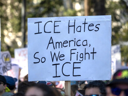 An anti-ICE protest sign rises above the crowd in Sacramento, California, United States