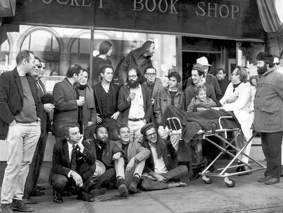Los poetas se reúnen en la librería City Lights en diciembre de 1965. Primera fila: hombre desconocido (izquierda), Shig Murao, Lew Welch y Peter Orlovsk. Fila central: Donald Schenker (izquierda), Michael Grieg, hombre desconocido, Mike Gibbons, David Miltger, Michael McClure, Allen Ginsberg, Dan Langton, Steve Brostan, Gary Goodraw y su hijo Homer, y Richard Brautigan (detrás de Goodrow). Fila de atrás: Stella Levy (izquierda) y Lawrence Ferlinghetti