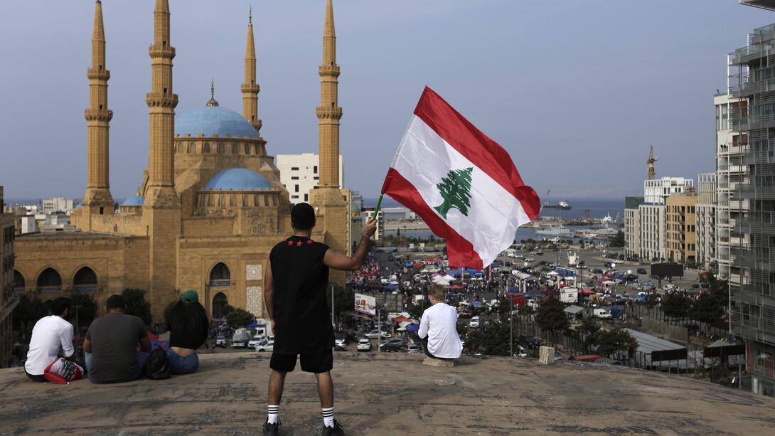 Manifestante ondeando una bandera libanesa durante una protesta en Beirut, Líbano, el 25 de octubre de 2019