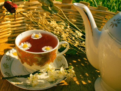 A soothing cup of herbal tea surrounded by fresh blossoms, representing the calming daily rituals that help lower blood pressure naturally