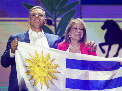 Yamandú Orsi y Carolina Cosse con la bandera uruguaya. Orsi destacó en su discurso la importancia del diálogo nacional para lograr soluciones consensuadas