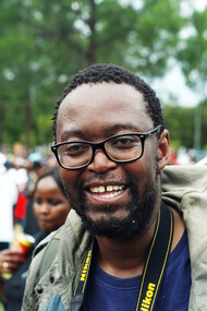 With the South African flag waving behind him, he embodies the spirit of unity and resilience in the fight for equity