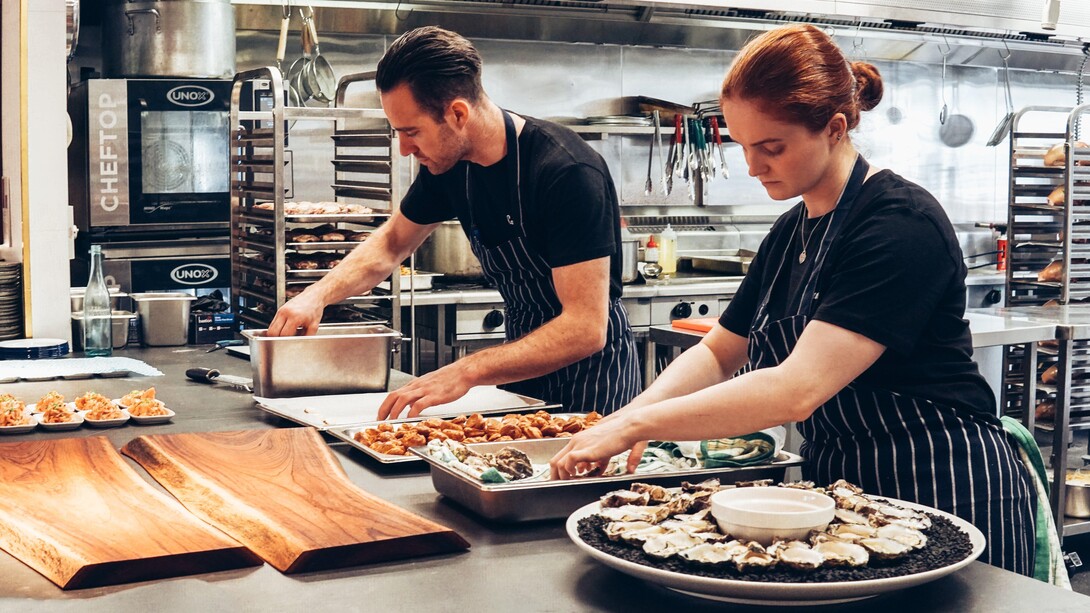 Chefes de cozinha preparam uma entrada para evento gastronômico