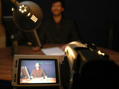 Un presentador de noticias real mostrado en el visor de la cámara