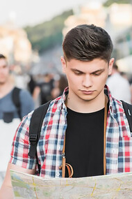 International student navigating academic migration while walking on the street with a map