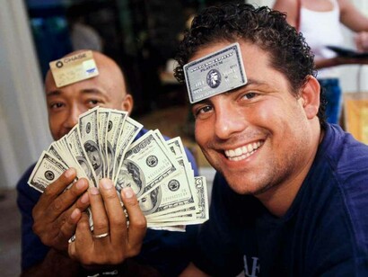 Film director and producer Brett Ratner (right), 29, and Russell Simmons, 41, a businessman and cofounder of hip-hop label Def Jam, at L’Iguane restaurant, St. Barts, 1998. Few establishments on the island accepted credit cards, and visitors often carried large amounts of cash. © Lauren Greenfield