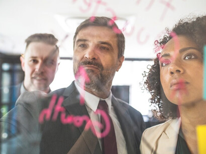 Business team collaborating on a glass wall, outlining goal setting, career planning, and strategies for professional growth and action plans