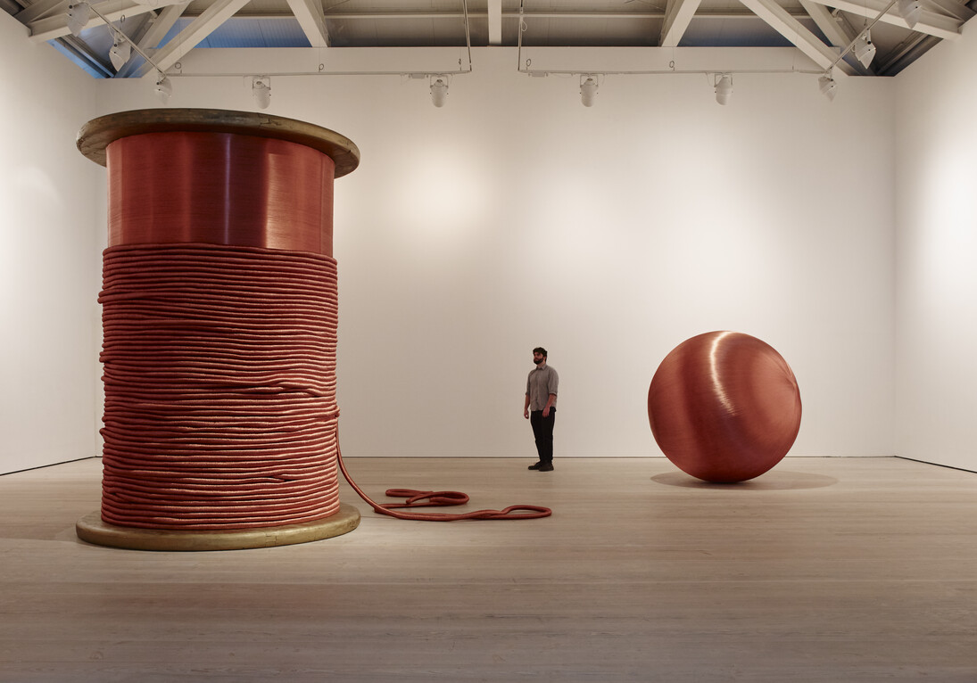 Alice Anderson, Left: Bound 2011 Bobbin made of wood and copper thread 345 x 248 x 248 cm,
Right: 181 Kilometers 2015 Sculpture made after performances, copper thread 200 cm (diameter) Image (c) Steve White, 2015, Courtesy of the Saatchi Gallery, London