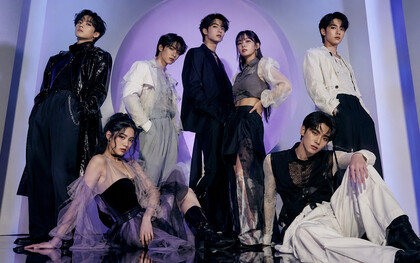 A K-pop-inspired group styled in layered monochrome looks, representing the theatrical fashion narratives central to idol culture