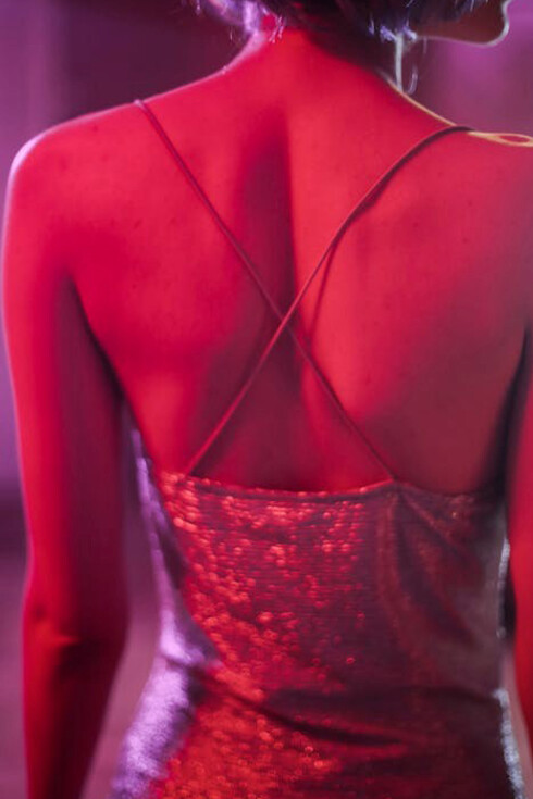 A Russian girl wearing a silvery dress and wig, gracefully dancing in the vibrant atmosphere of a nightclub