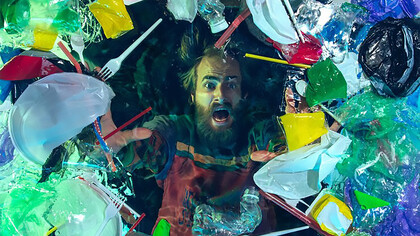 A man drowning in water beneath a pile of plastic containers and garbage, highlighting the environmental crisis and the impact of pollution on ecosystems