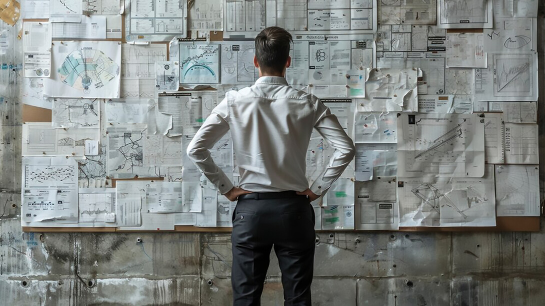 A portrait of a male engineer analyzing graphs, reflecting the strategic and operational decision-making processes that guide critical decisions in his work