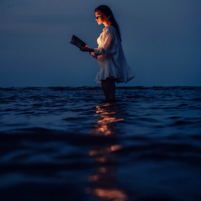 Mulher se conecta com livro espiritual enquanto aterra os pés na natureza