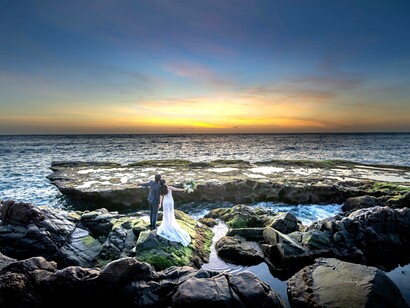 A couple greeting the view of the far sea on the horizon
