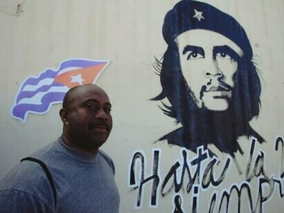 Homem em frente à pixação com rosto de Che Guevara. É essencial o requisito de mediadores, o engajamento do público, a união faz a força e o público torna-se a peça final da obra de arte perfeita