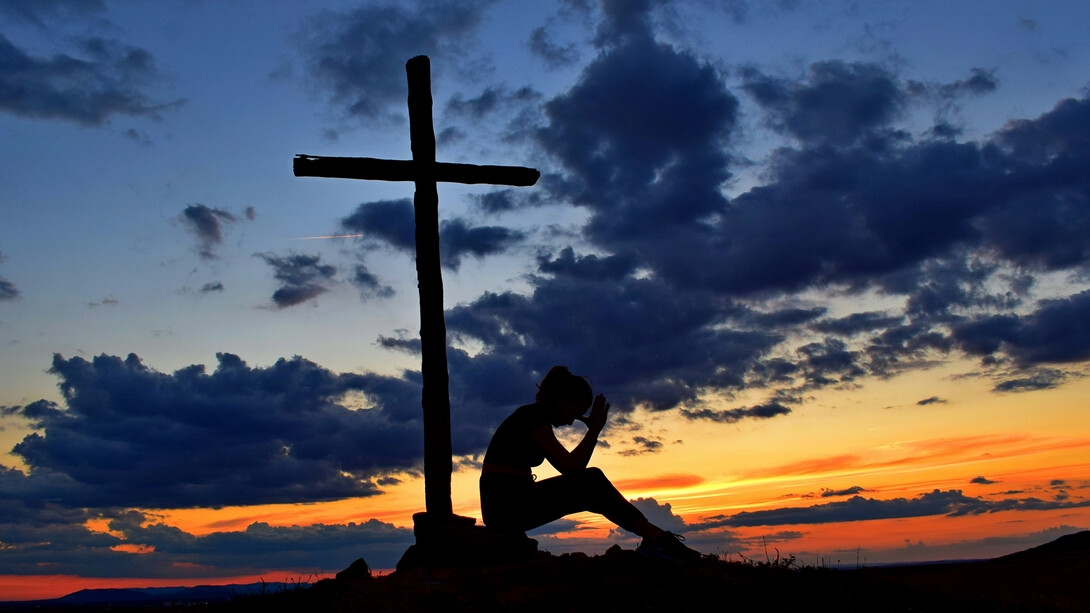 Mujer solitaria reza junto a una humilde cruz. En busca de respuestas, continuamos nuestra indagación