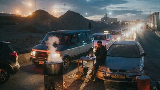 Un hombre espera entre una fila de coches a pocos metros de un puesto de control en Ramala, Palestina, para entrar en Israel