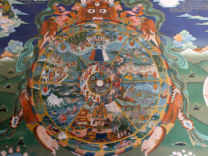 Bhavachakra showing six realms of existence in which a being can reincarnate according to rebirth doctrine of Buddhism. Buddhist god Yama face is at the top of the outer rim. The outer rim shows the twelve nidanas doctrine. From Bhutan