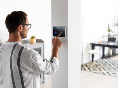 User interacts with a smart control panel, showcasing IoT’s role in connected home environments 