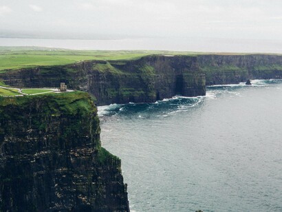 Falésias de Moher, na costa ocidental da Irlanda. As falésias oferecem uma vista vertiginosa sobre o Atlântico e revelam camadas geológicas que contam milhões de anos de história. Pelo caminho, seguimos junto à costa, cruzando paisagens verdes salpicadas de vacas e ovelhas — o retrato clássico da Irlanda rural