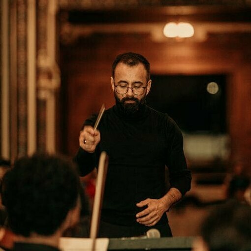 Berny Siles dirigiendo al coro y la orquesta durante la presentación de su misa de réquiem