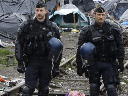 French gendarmes stand guard near makeshift shelters 