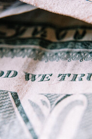 Dettaglio di un dollaro con scritto "In God we trust"
