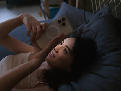 A woman scrolls through her phone late at night, highlighting the grip of social media addiction
