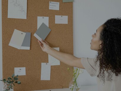 A woman amending a few elements on her idea validation board