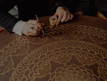 Pintura à mão de mandalas douradas em fundo de madeira